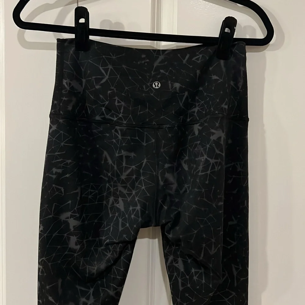 Lightly worn galaxy pattern black Lululemon no size tag leggings measures at 8